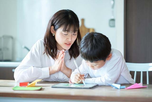 子どもの勉強を見守る母親