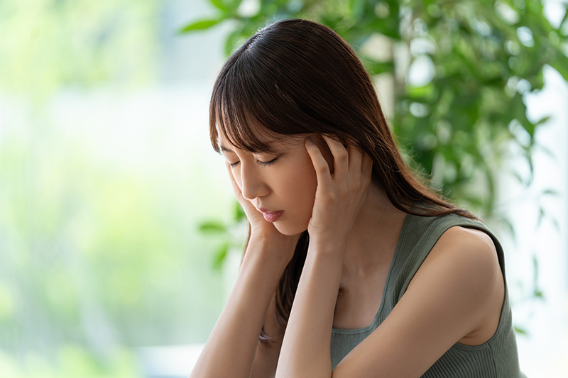 頭を押さる女性